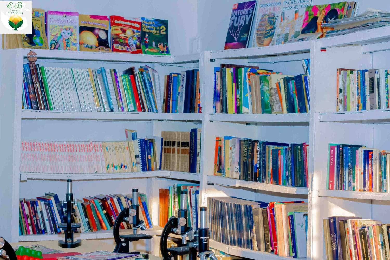 Bookshelves filled with educational books and microscopes in the community library